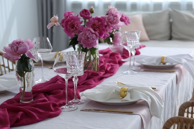 Photo of Beautiful table setting with pink peonies in dining room