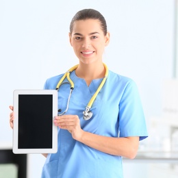 Portrait of young medical assistant with stethoscope and tablet in hospital. Space for text