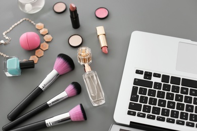 Photo of Makeup products for woman and laptop on table