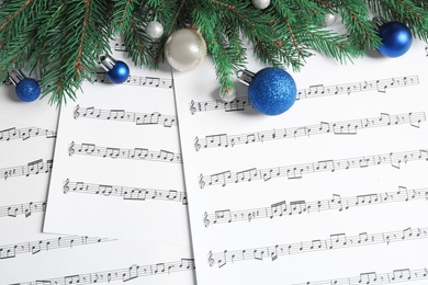 Flat lay composition with Christmas decorations on music sheets