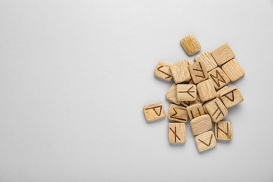 Pile of wooden runes on white background, flat lay. Space for text