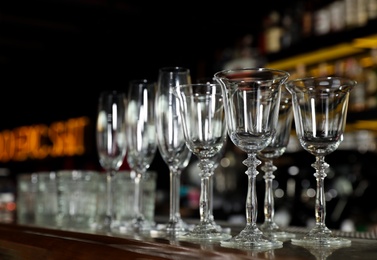 Different empty clean glasses on counter in bar