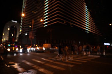 BATUMI, GEORGIA - JUNE 09, 2022: Blurred view of people crossing street in city. Night life