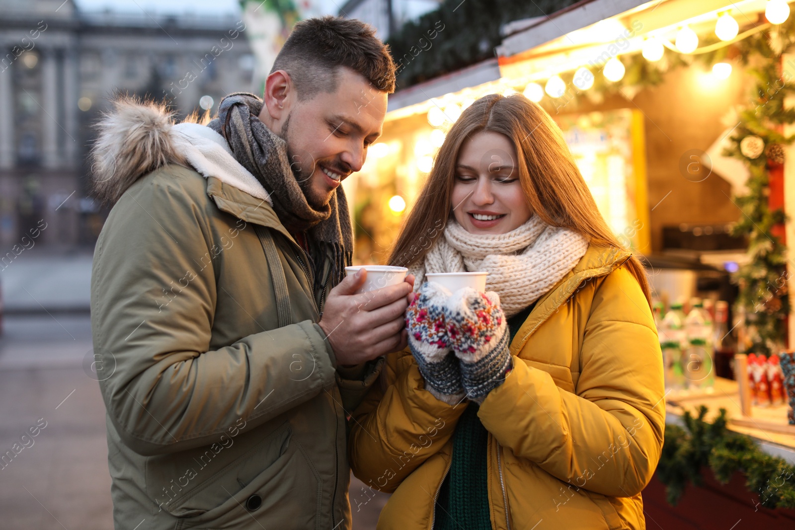 Photo of Happy couple with mulled wine at winter fair