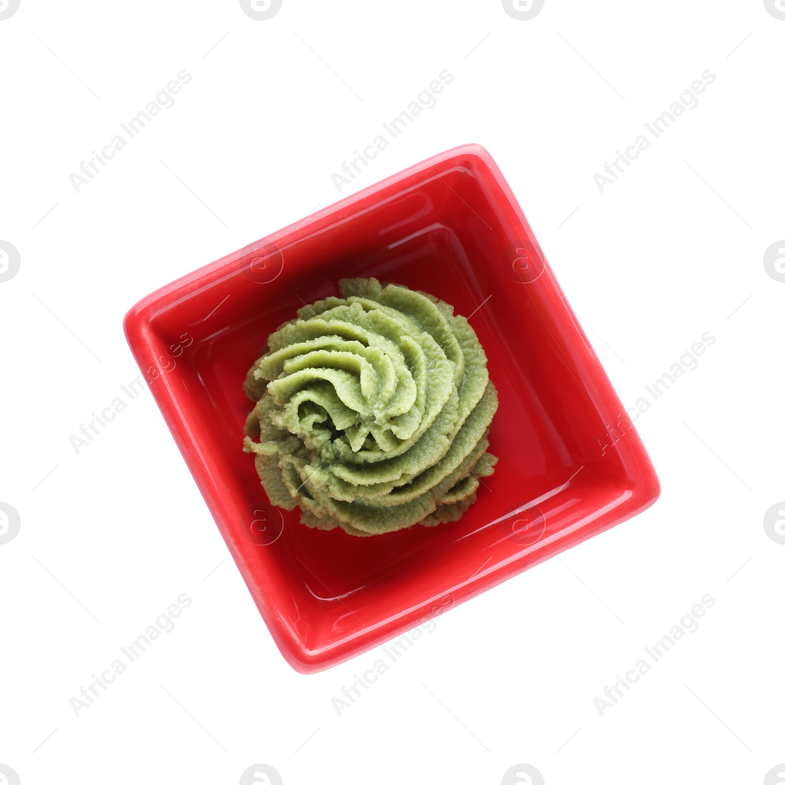 Photo of Bowl with swirl of wasabi paste isolated on white, top view