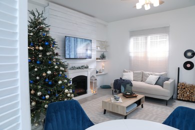 Photo of Stylish living room interior with modern TV, fireplace and Christmas tree