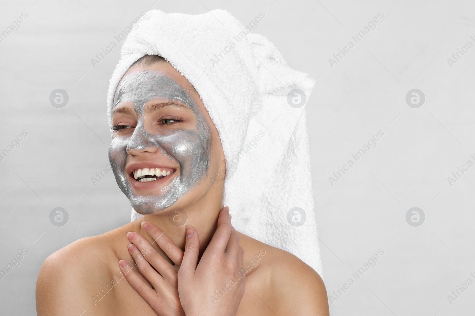 Photo of Beautiful woman with silver mask on her face against light background. Space for text