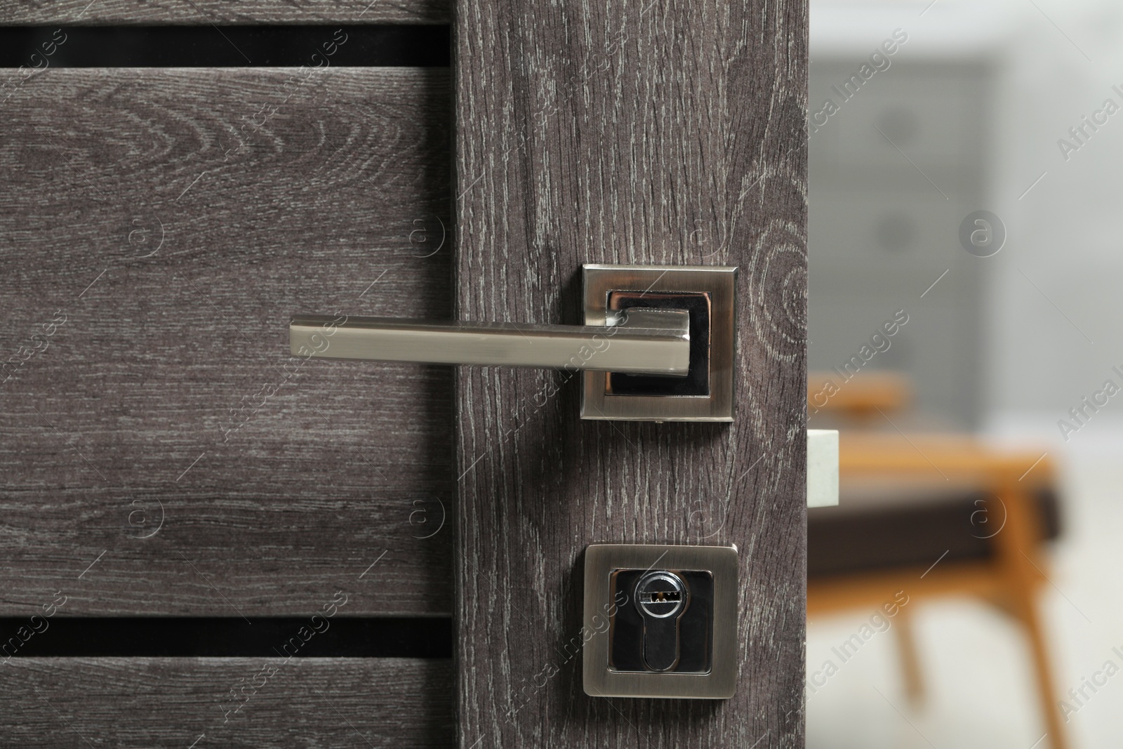 Photo of Open wooden door with metal handle, closeup