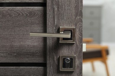 Open wooden door with metal handle, closeup