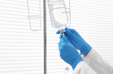 Photo of Nurse setting up IV drip in hospital, closeup