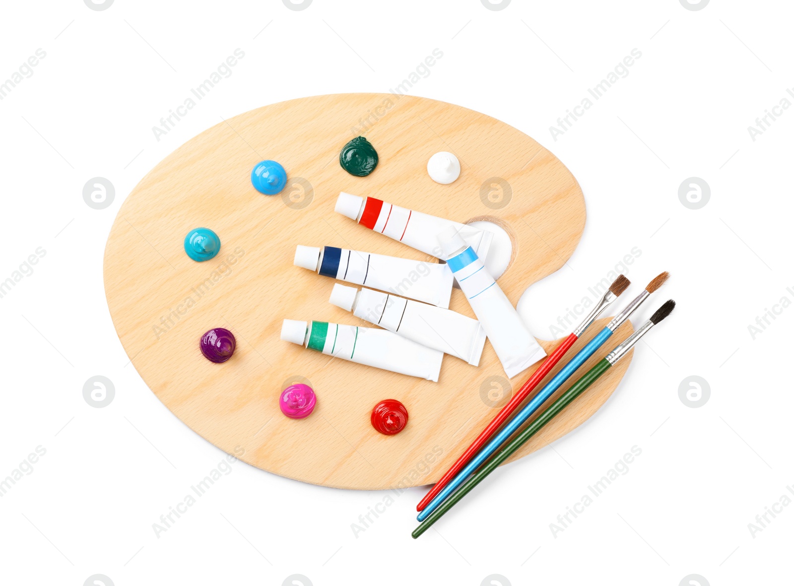 Photo of Wooden artist's palette with brushes and paints isolated on white, top view