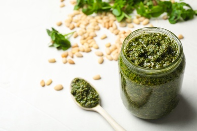 Photo of Composition with homemade basil pesto sauce on table. Space for text