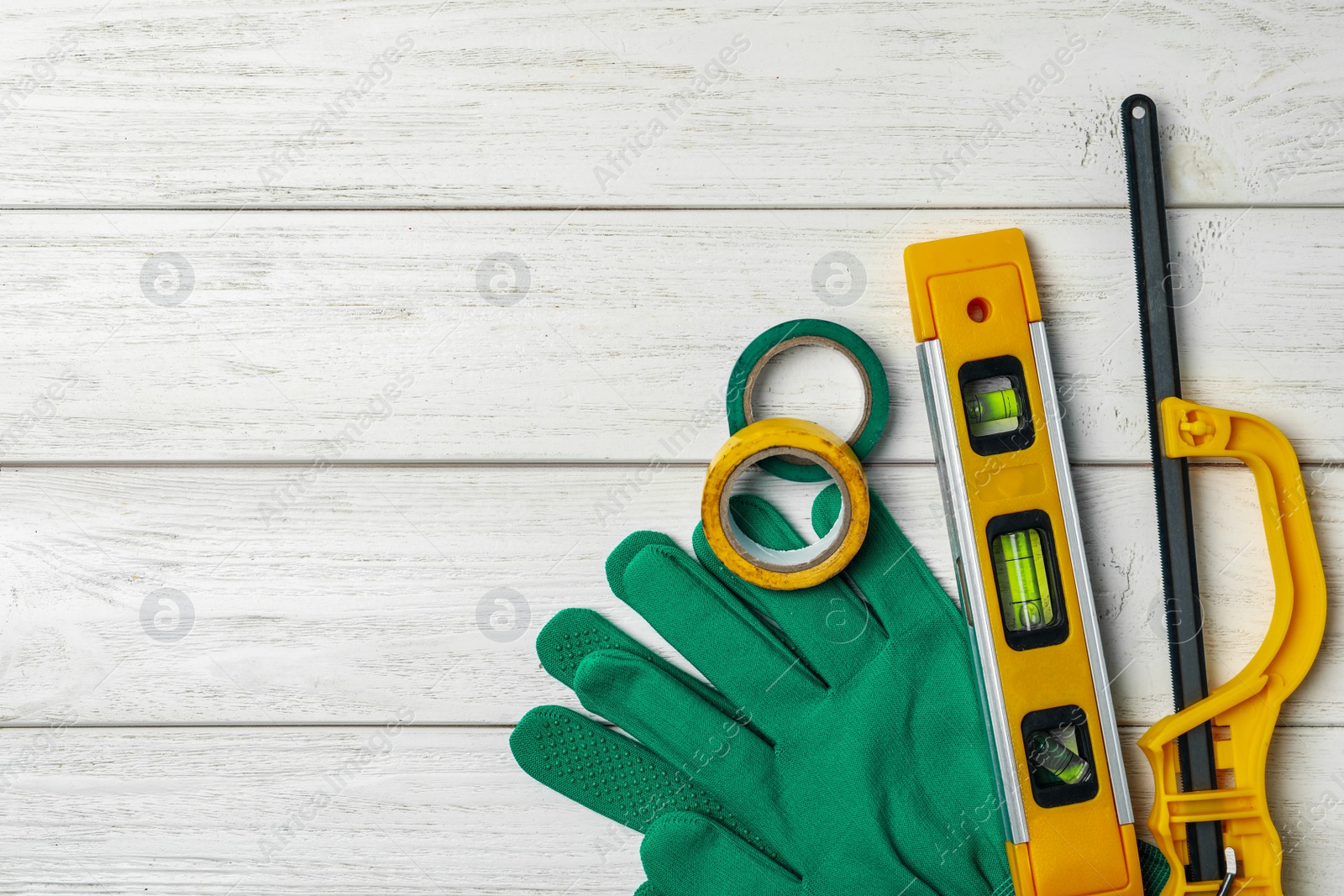 Photo of Flat lay composition with carpenter's tools on white wooden background. Space for text