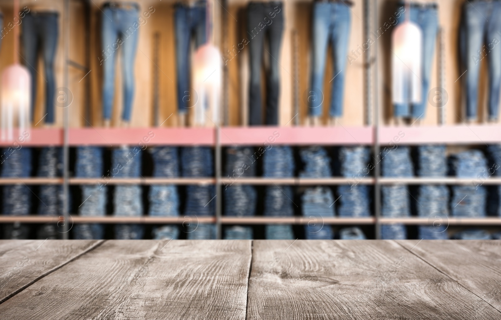 Image of Empty wooden table and blurred view of store with modern clothes