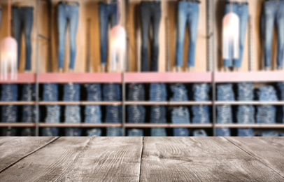 Image of Empty wooden table and blurred view of store with modern clothes