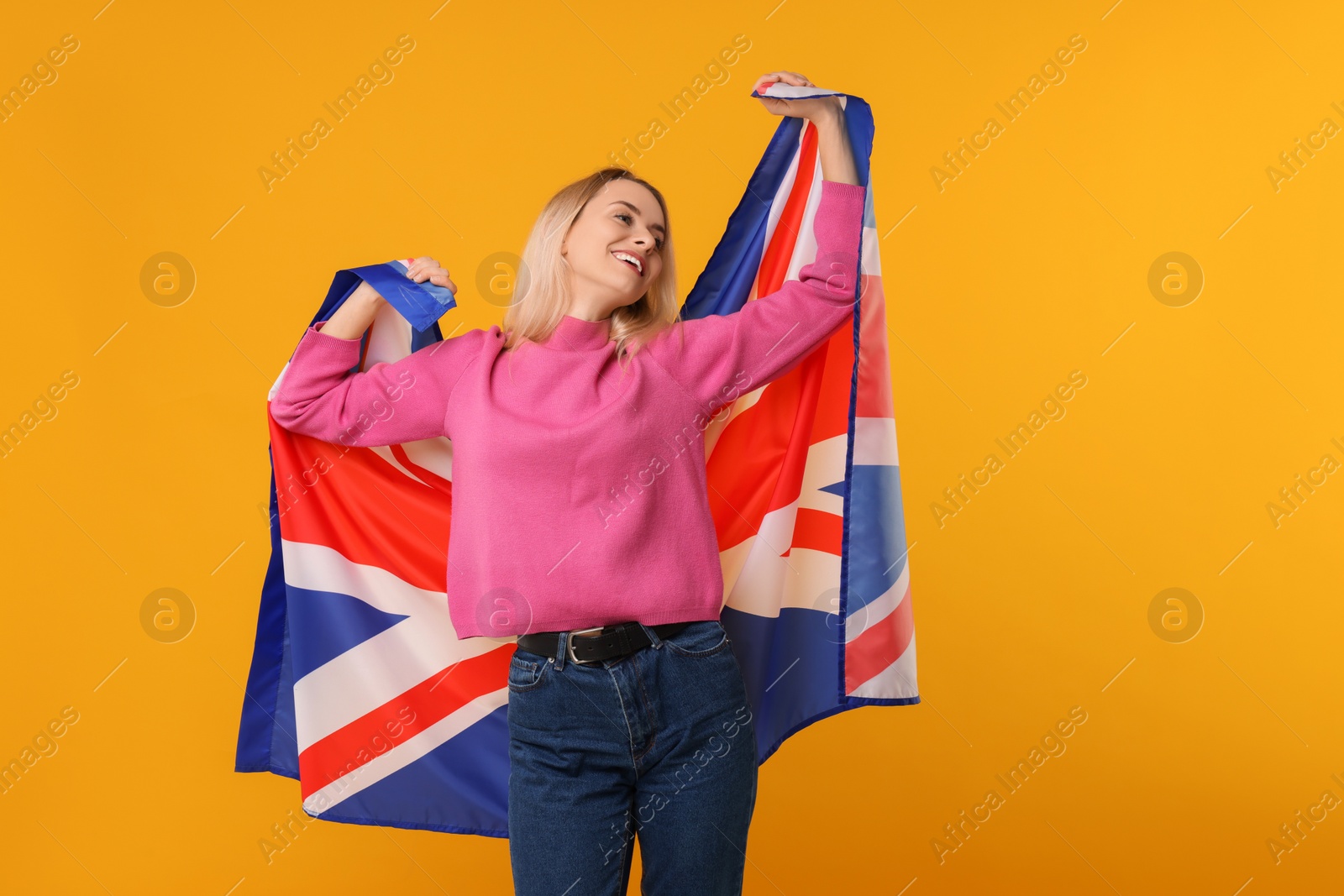 Photo of Happy woman with flag of United Kingdom on orange background