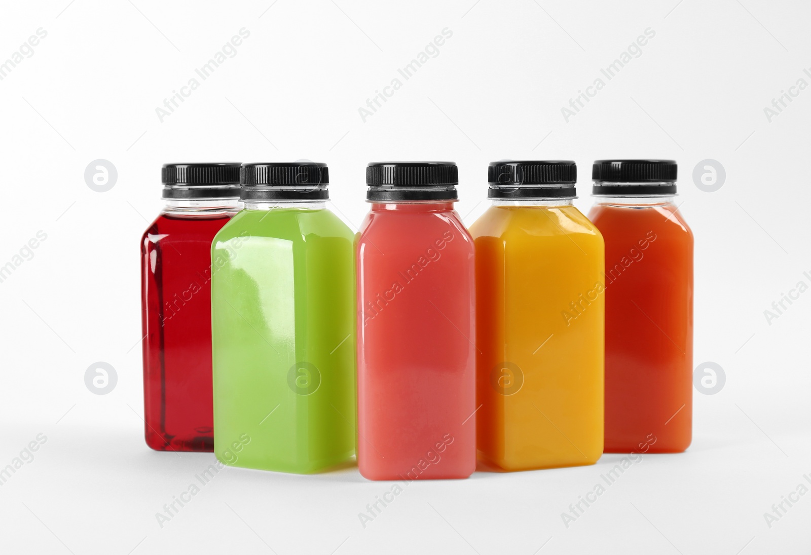 Photo of Bottles with delicious colorful juices on white background