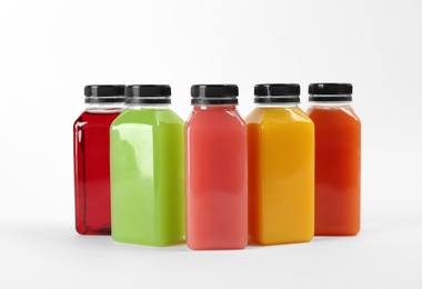 Photo of Bottles with delicious colorful juices on white background