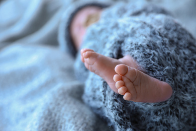 Photo of Newborn baby lying on blanket, closeup of legs. Space for text
