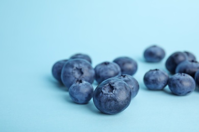 Tasty ripe blueberry on color background, closeup