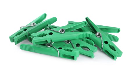 Photo of Bright green plastic clothespins on white background