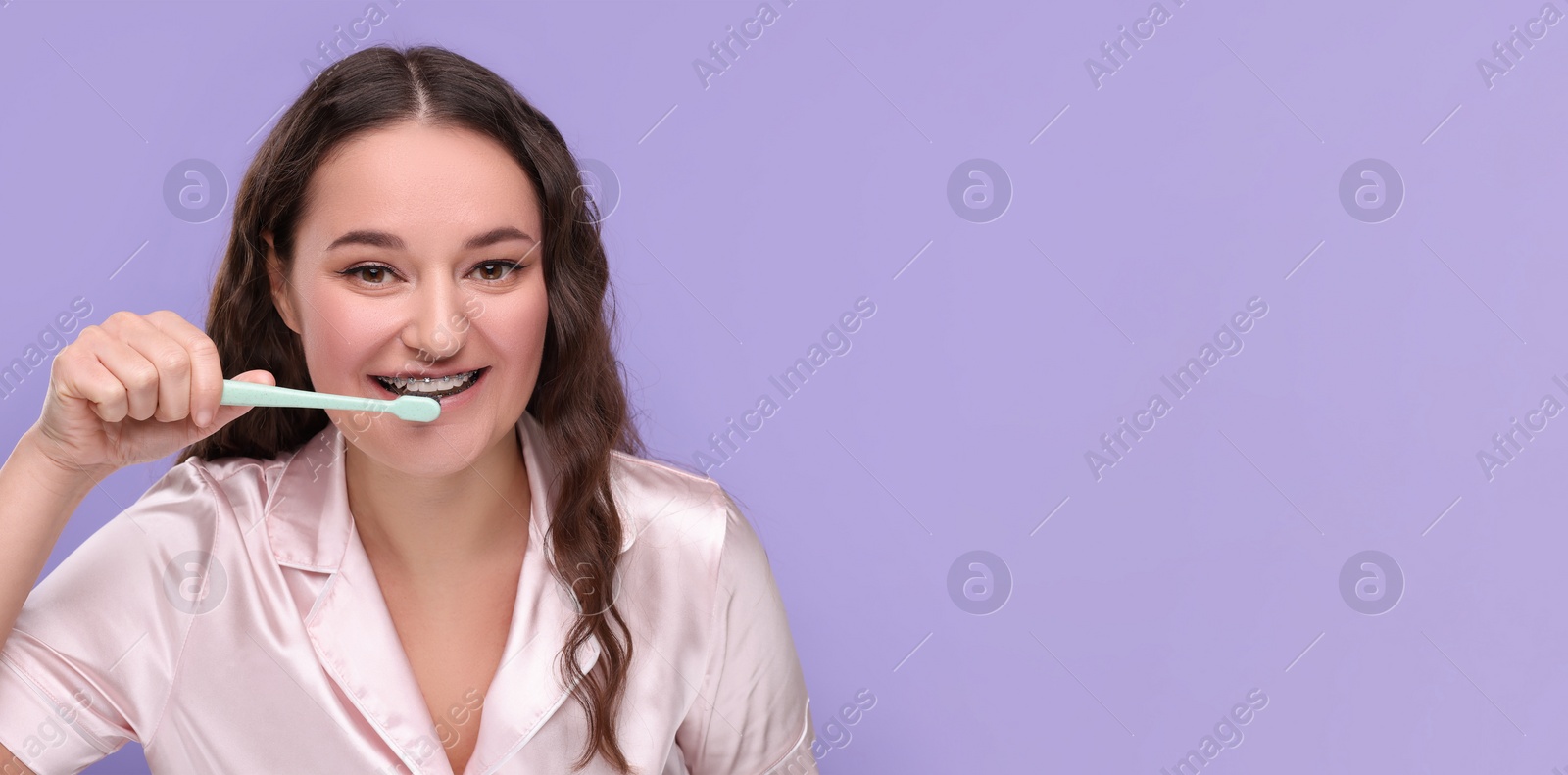 Image of Woman with braces cleaning teeth on violet background. Banner design with space for text