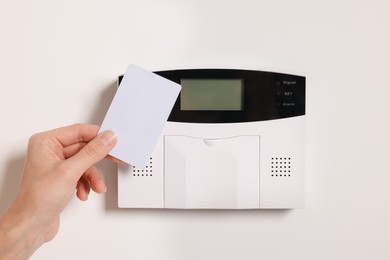 Photo of Home security system. Woman using key card, closeup