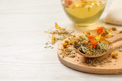 Photo of Mix of dried herbs and tea on white wooden table. Space for text