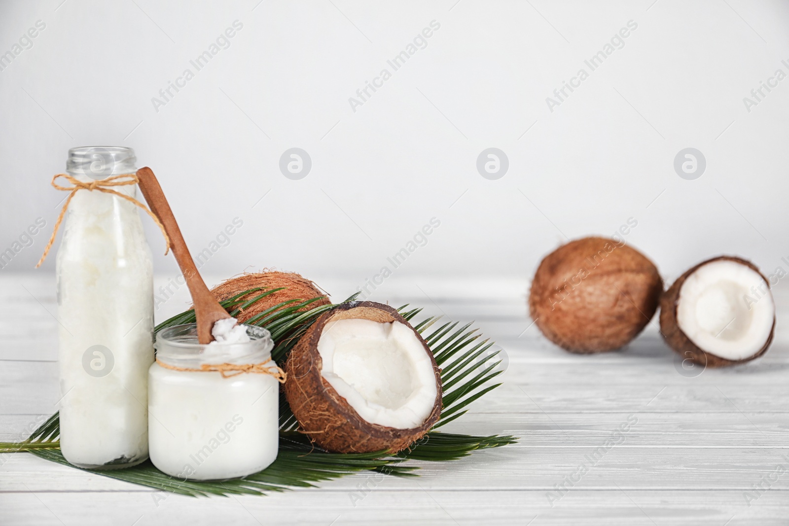 Photo of Composition with fresh coconut oil on white wooden table, space for text. Cooking ingredient