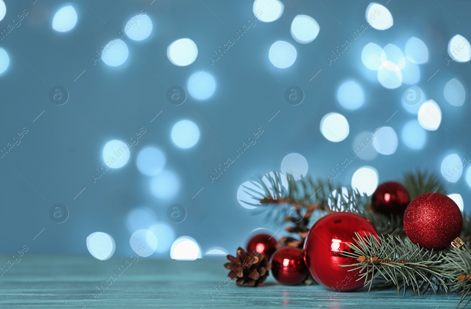 Photo of Christmas decoration on table against blurred lights. Space for text