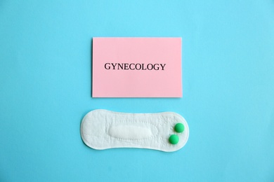 Photo of Flat lay composition with menstrual pad and pills on color background. Gynecological care