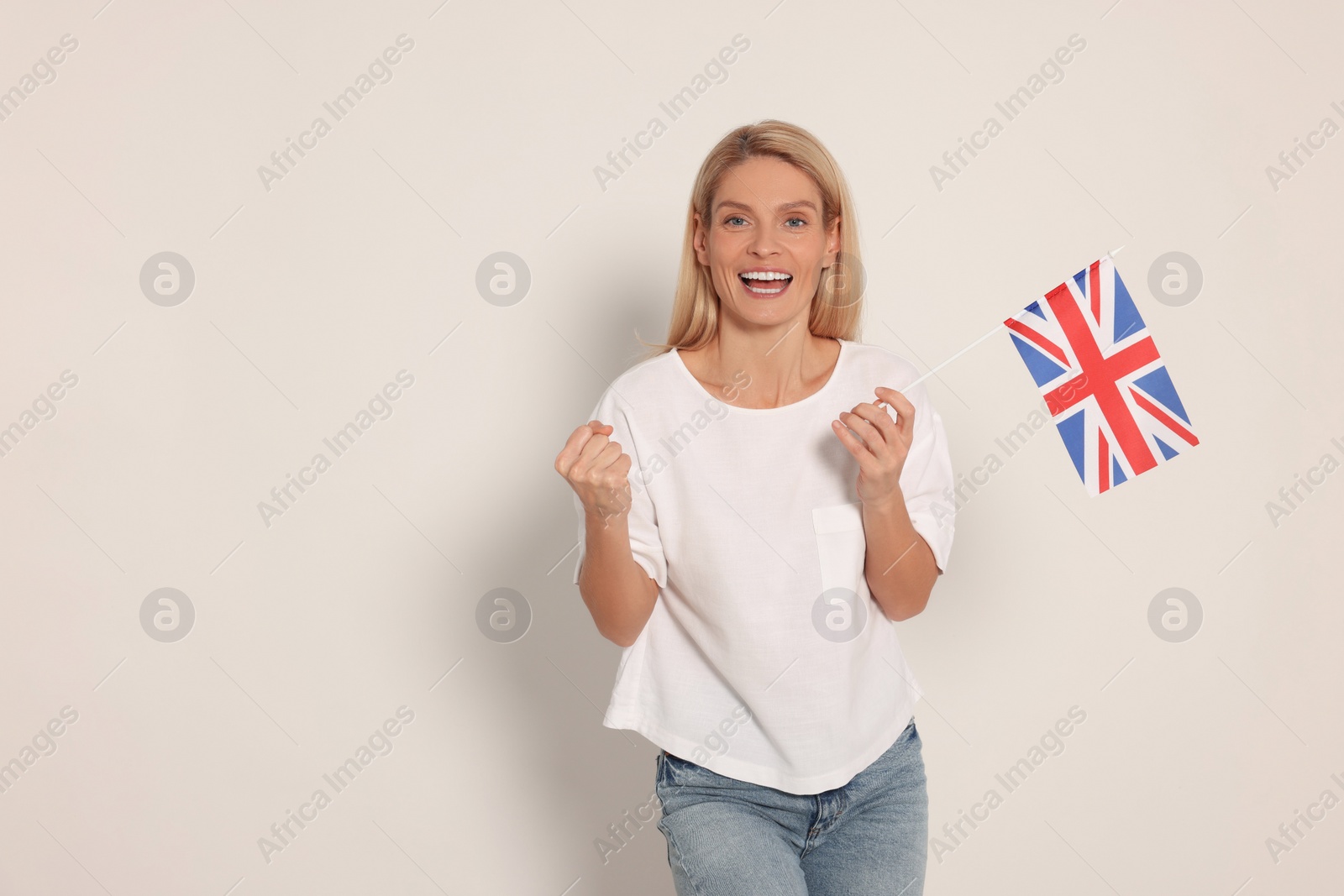 Photo of Emotional woman with flag of United Kingdom on white background, space for text