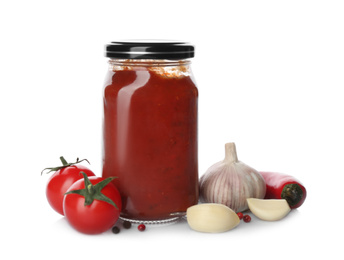 Jar of tomato paste and fresh ingredients on white background