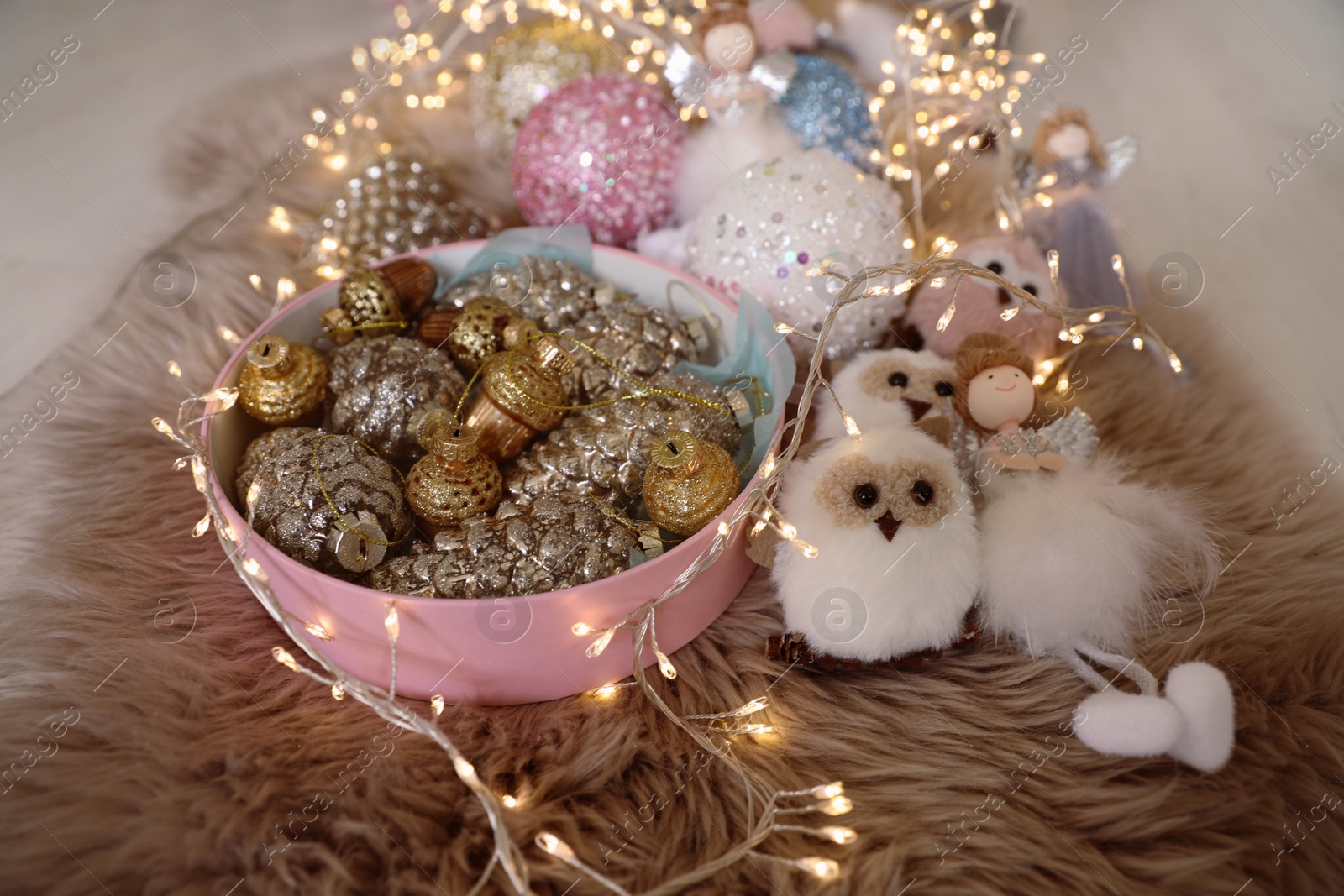 Photo of Beautiful Christmas tree baubles, toys and fairy lights on faux fur