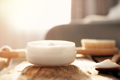 Photo of Jar with body care cream on wooden table