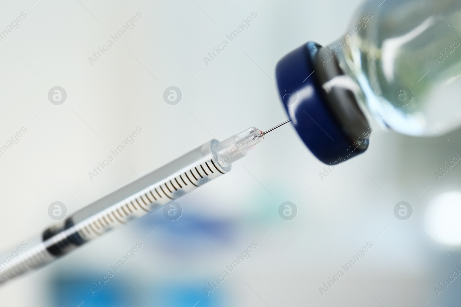 Photo of Filling syringe with vaccine on blurred background, closeup