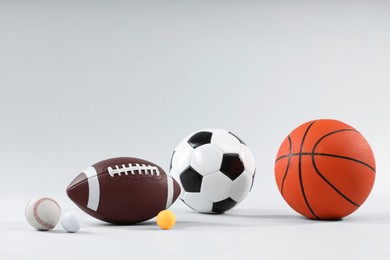 Photo of Many different sports balls on light gray background, space for text