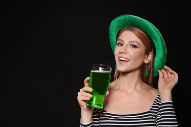 Young woman with green beer on black background. St. Patrick's Day celebration