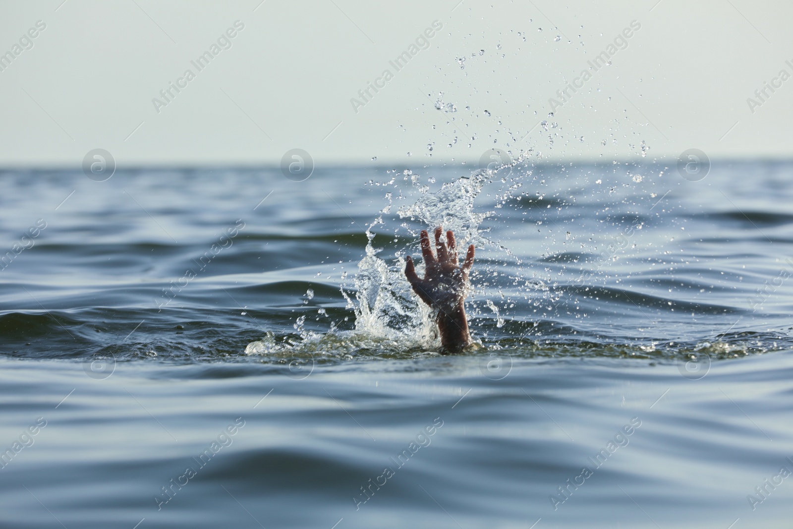 Photo of Drowning woman reaching for help in sea