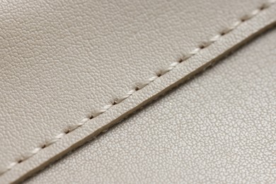 Photo of Beige leather with seam as background, closeup view