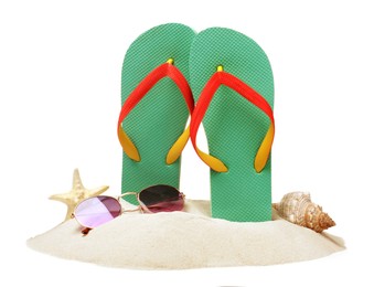 Turquoise flip flops in sand, sea shell, starfish and sunglasses on white background