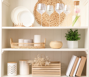 Photo of White shelving unit with dishware and different decorative stuff