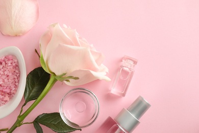 Photo of Flat lay composition with rose essential oil on pink background, space for text