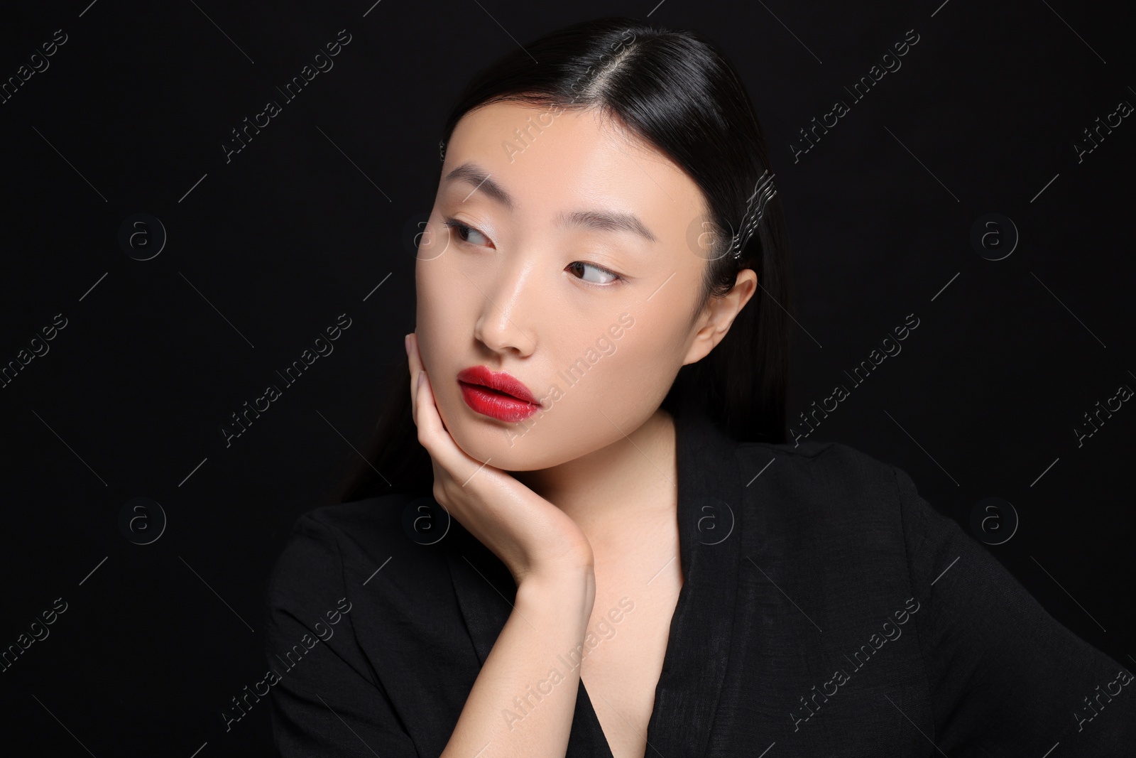 Photo of Portrait of beautiful young Asian woman on black background