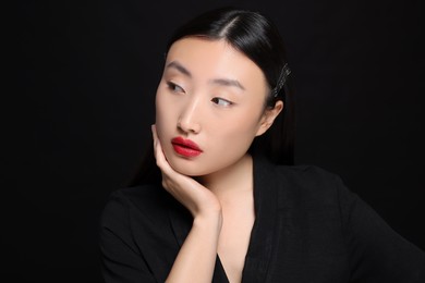 Photo of Portrait of beautiful young Asian woman on black background