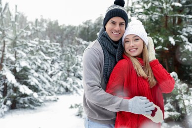 Photo of Beautiful happy couple in snowy forest on winter day