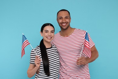Photo of 4th of July - Independence Day of USA. Happy couple with American flags on light blue background