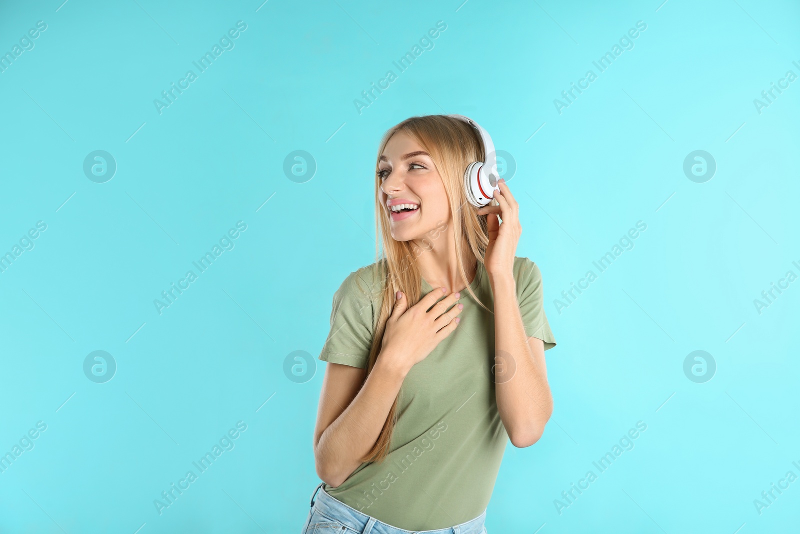 Photo of Beautiful young woman listening to music with headphones on color background