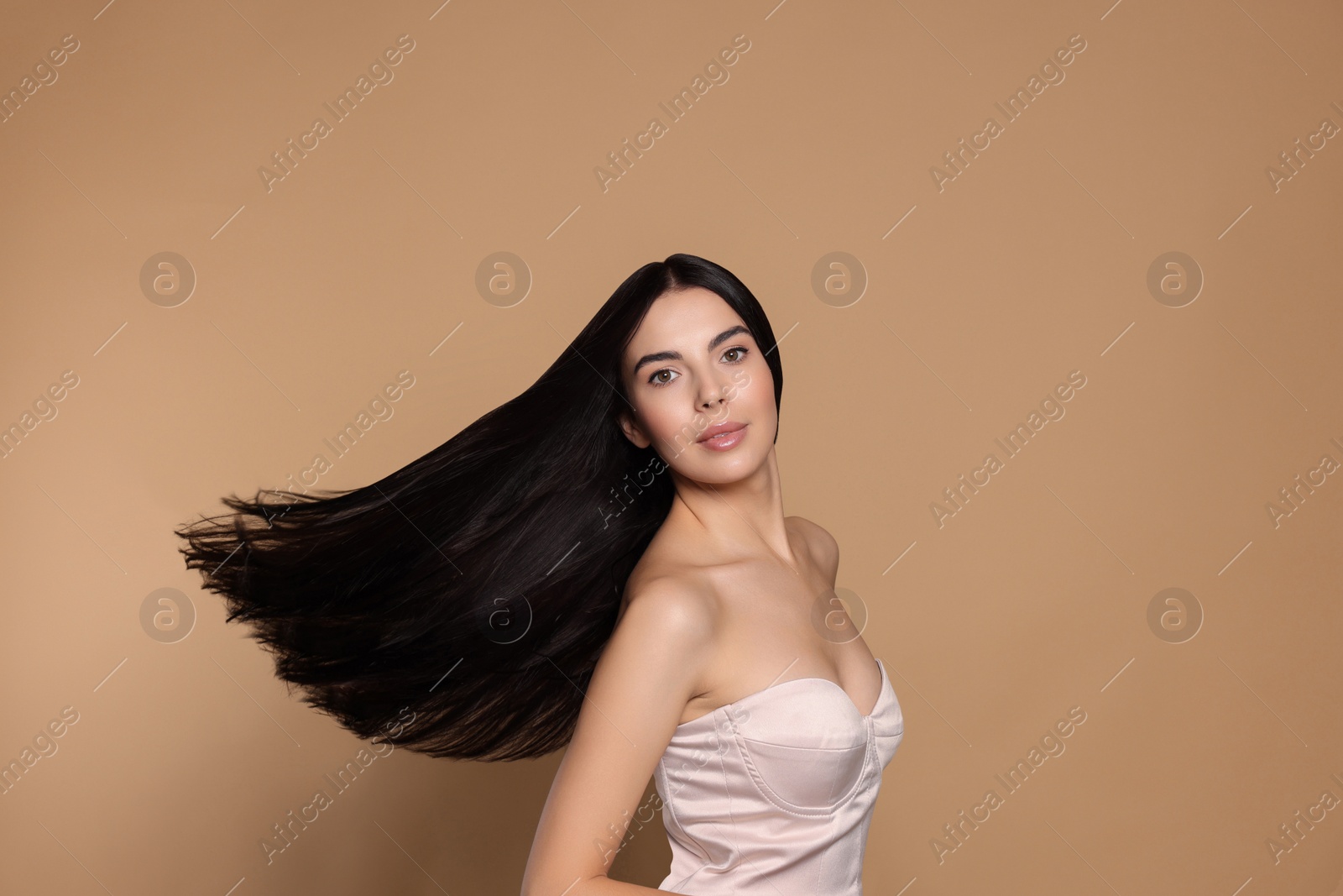 Photo of Portrait of beautiful young woman with healthy strong hair on beige background