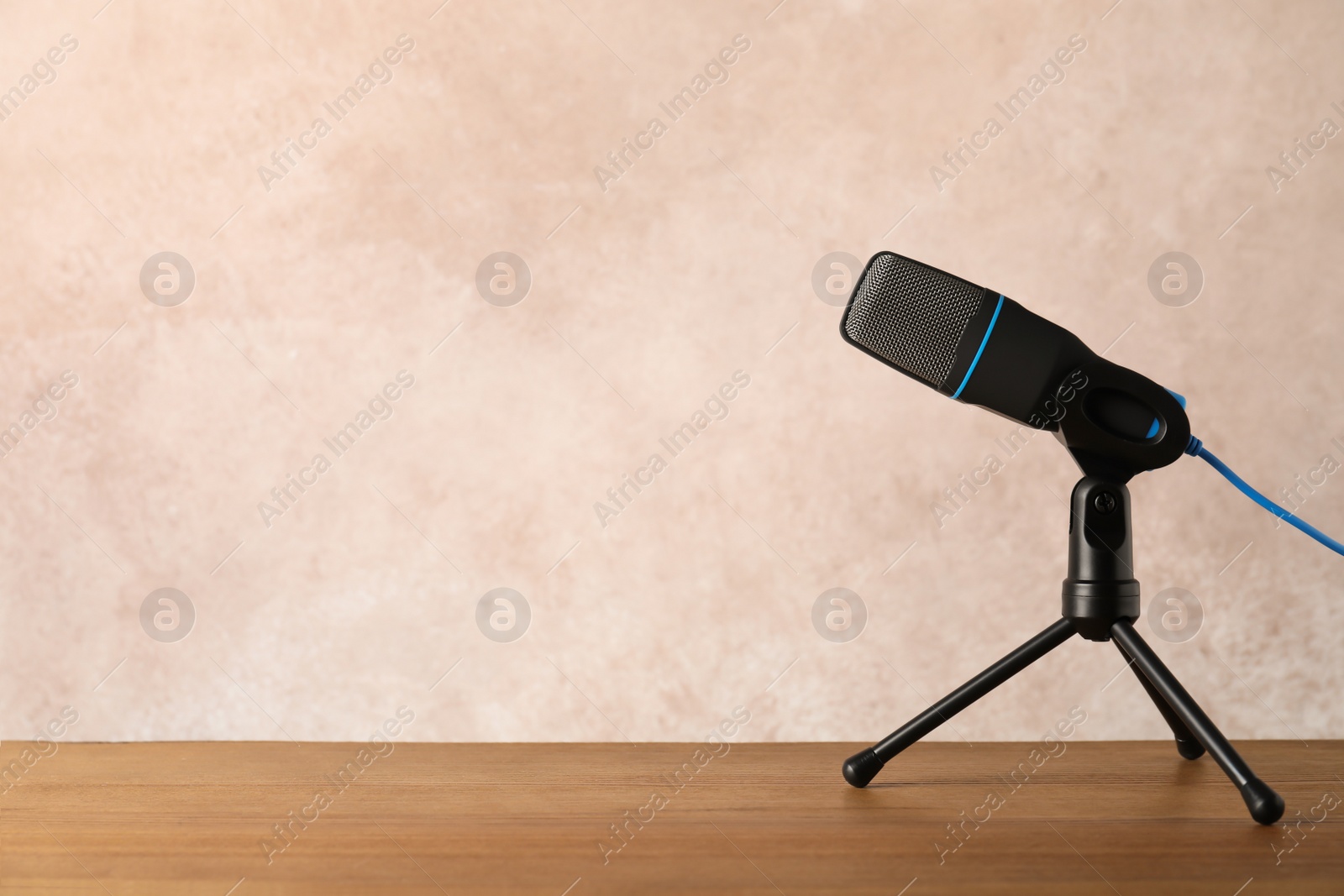 Photo of Microphone on table against color background. Space for text